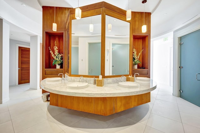full bath featuring tile patterned floors, double vanity, and baseboards