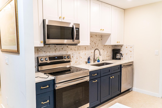 kitchen featuring stainless steel appliances, a sink, white cabinetry, and tasteful backsplash