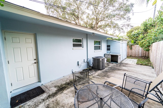 view of patio / terrace with outdoor dining area, cooling unit, and a fenced backyard