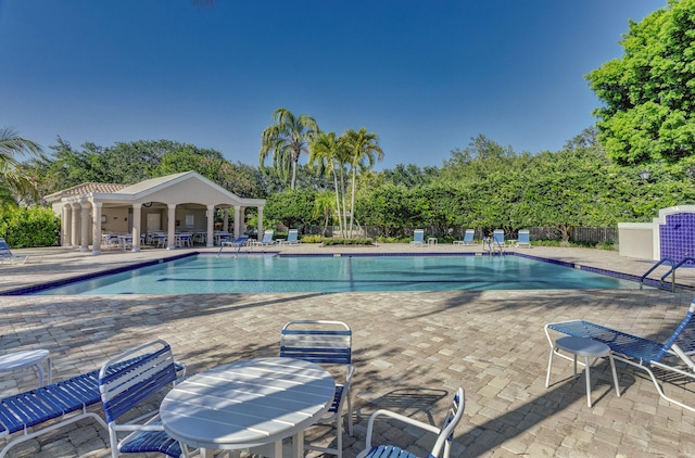 community pool featuring a patio and fence