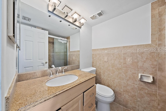 210 Lake Pointe Dr Unit 310, Oakland Park, FL 33309 - full bathroom with tile walls, a shower stall, toilet, vanity, and a wainscoted wall