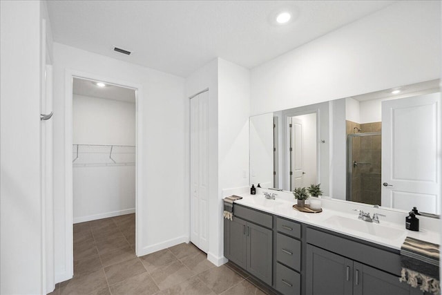 3527 Angler Dr, Fort Pierce, FL 34946 - bathroom with a stall shower, a walk in closet, double vanity, baseboards, and tile patterned flooring