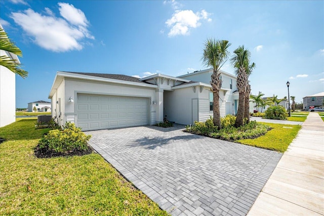 3527 Angler Dr, Fort Pierce, FL 34946 - view of front facade with a garage, decorative driveway, stucco siding, a front yard, and central AC