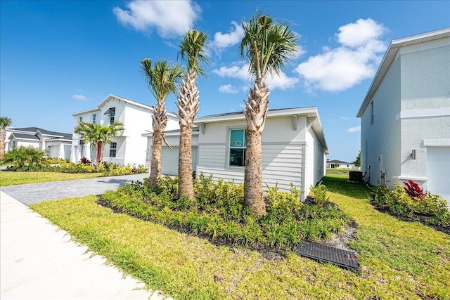 3527 Angler Dr, Fort Pierce, FL 34946 - view of front facade with driveway, a front lawn, stucco siding, and cooling unit