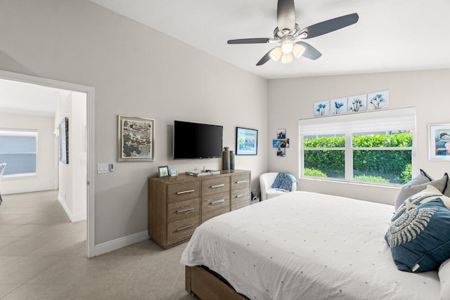bedroom featuring baseboards, light tile patterned floors, and ceiling fan