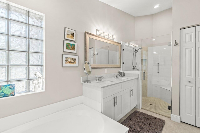 bathroom with a shower stall, a tub to relax in, and double vanity
