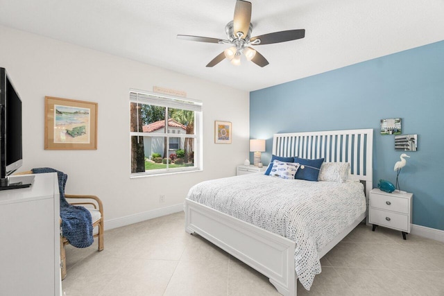 bedroom featuring baseboards, a ceiling fan, and light tile patterned floors