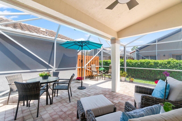 view of patio / terrace featuring outdoor lounge area, ceiling fan, glass enclosure, and outdoor dining area