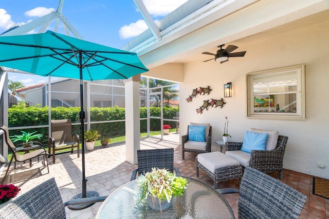 view of patio with glass enclosure and a ceiling fan