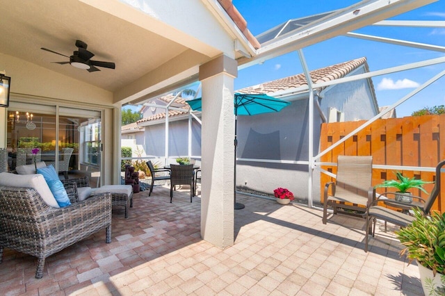 view of patio / terrace with ceiling fan, a lanai, and outdoor dining area