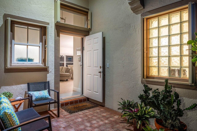 view of exterior entry featuring stucco siding and covered porch