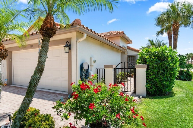 view of home's exterior featuring an attached garage, stucco siding, a tiled roof, driveway, and a lawn