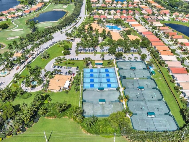 aerial view of property and surrounding area with a large body of water, a local golf course, and nearby suburban area