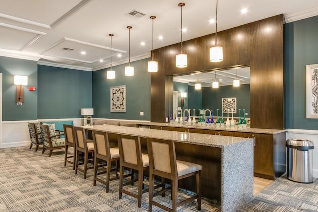 bar area featuring coffered ceiling, crown molding, light colored carpet, a wainscoted wall, and a decorative wall