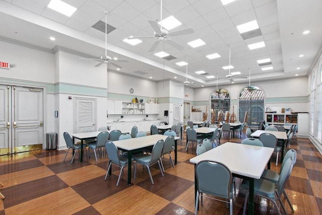 dining room featuring ceiling fan, a high ceiling, a drop ceiling, a tray ceiling, and wood finished floors