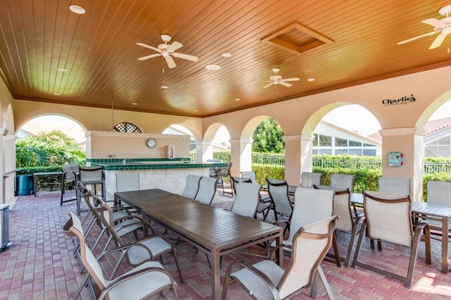 view of patio / terrace featuring ceiling fan, outdoor dining area, and a bar