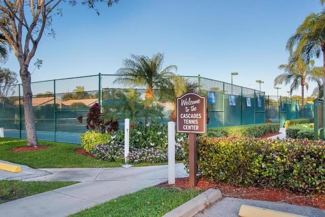 view of home's community featuring fence and a tennis court
