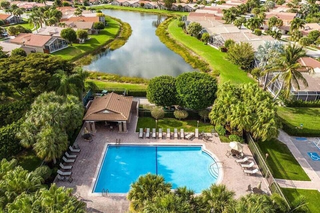 aerial perspective of suburban area featuring a pool area and a large body of water
