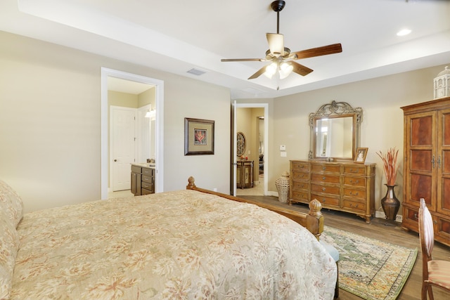 4885 SW Gossamer Cir, Palm City, FL 34990 - bedroom with a tray ceiling, wood finished floors, recessed lighting, ensuite bath, and a ceiling fan