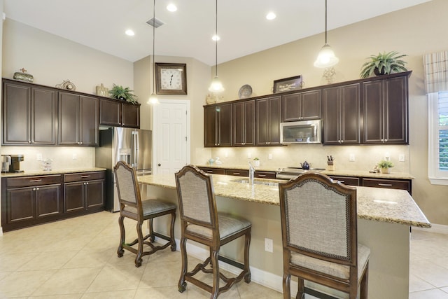4885 SW Gossamer Cir, Palm City, FL 34990 - kitchen with appliances with stainless steel finishes, dark brown cabinets, a breakfast bar, tasteful backsplash, and recessed lighting