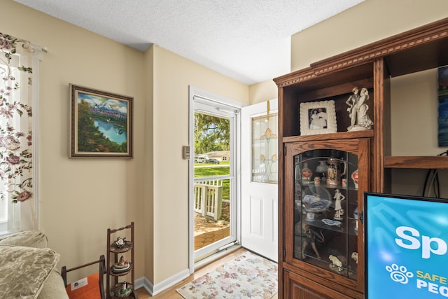 7302 Banyan St, Fort Pierce, FL 34951 - doorway with wood finished floors, a textured ceiling, and baseboards