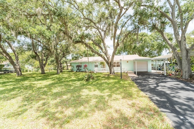 7302 Banyan St, Fort Pierce, FL 34951 - ranch-style home featuring a garage, asphalt driveway, a front yard, and a carport