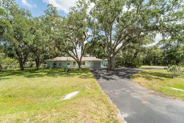 7302 Banyan St, Fort Pierce, FL 34951 - ranch-style home with an attached garage, asphalt driveway, and a front lawn