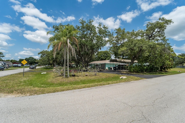 7302 Banyan St, Fort Pierce, FL 34951 - view of front facade with a front yard, a detached carport, and driveway