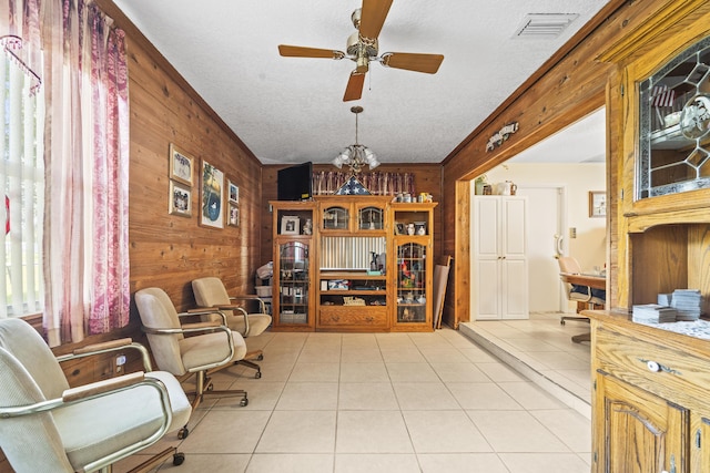 7302 Banyan St, Fort Pierce, FL 34951 - living area featuring wooden walls, ceiling fan, light tile patterned floors, a textured ceiling, and a chandelier
