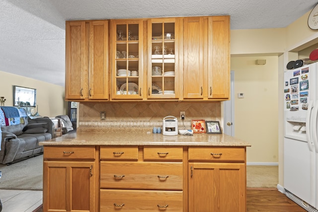 7302 Banyan St, Fort Pierce, FL 34951 - kitchen with white refrigerator with ice dispenser, glass insert cabinets, tasteful backsplash, a textured ceiling, and open floor plan