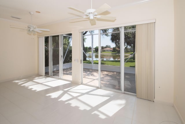 spare room with a water view, crown molding, baseboards, ceiling fan, and tile patterned flooring