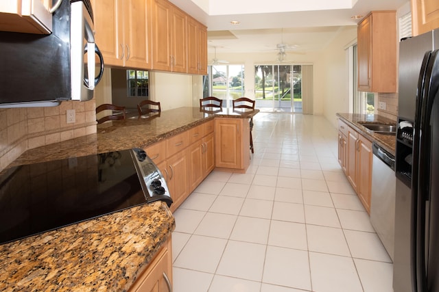 kitchen with tasteful backsplash, black fridge with ice dispenser, light tile patterned floors, a peninsula, and recessed lighting
