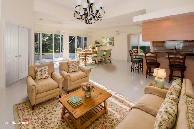 tiled living room with a ceiling fan, a chandelier, ornamental molding, and a sink