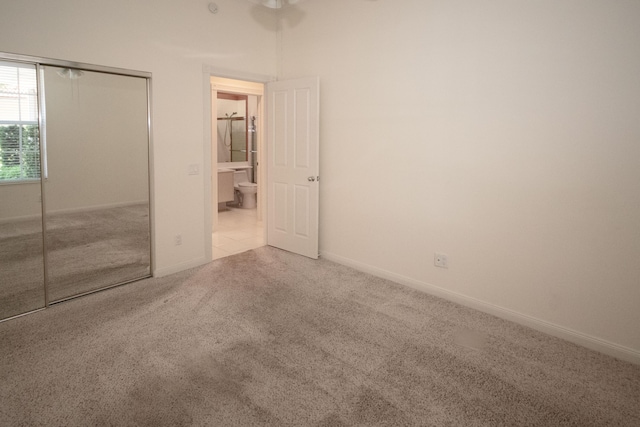 unfurnished bedroom featuring carpet flooring, a closet, and baseboards