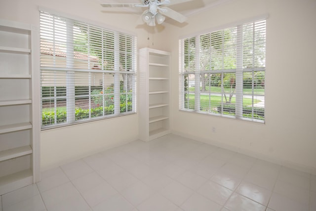 empty room with healthy amount of natural light, a ceiling fan, and baseboards