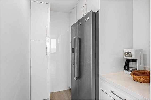 kitchen with high end fridge, white cabinetry, light countertops, and modern cabinets