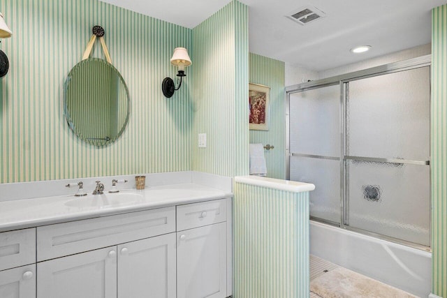 full bath with wallpapered walls, bath / shower combo with glass door, vanity, and tile patterned flooring
