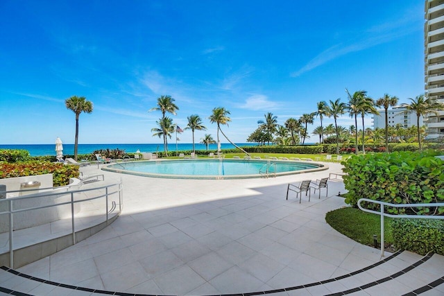 community pool featuring a patio and a water view