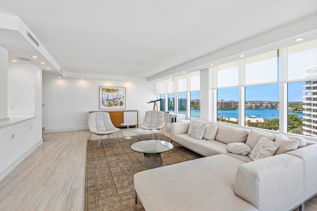 living room featuring a water view, baseboards, a city view, and recessed lighting