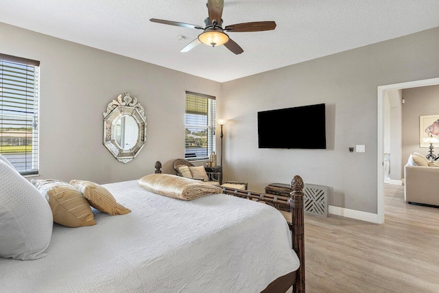 bedroom featuring light wood finished floors, baseboards, and ceiling fan