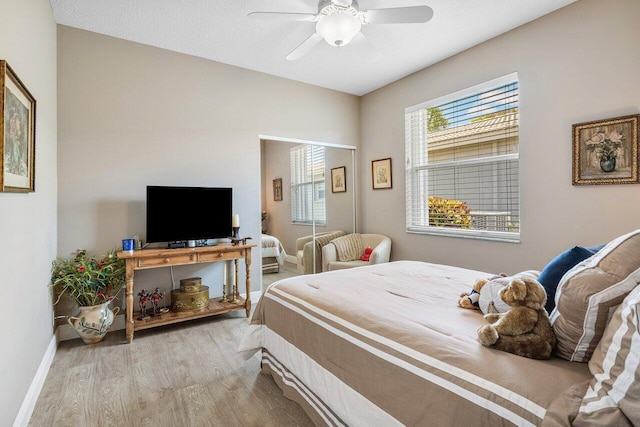 bedroom with wood finished floors, baseboards, and ceiling fan