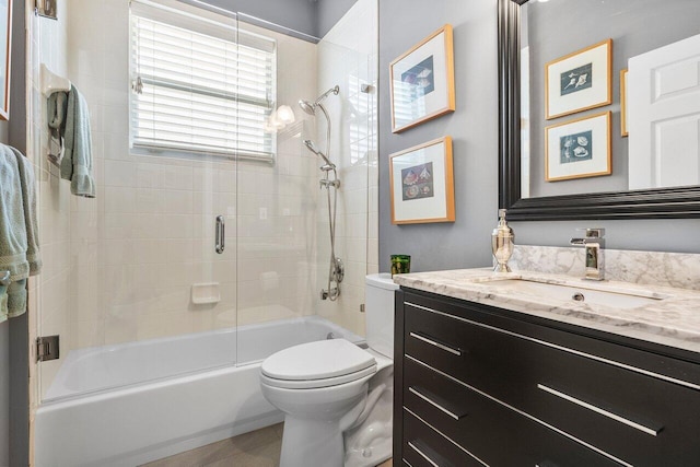 full bath with toilet, vanity, combined bath / shower with glass door, and tile patterned floors