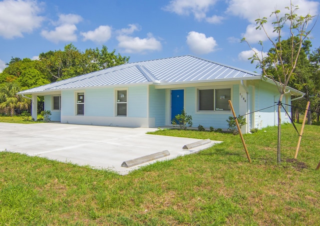 1106 Avenue E Ave E Apt B, Fort Pierce, FL 34950 - view of front of home with a standing seam roof, metal roof, and a front lawn