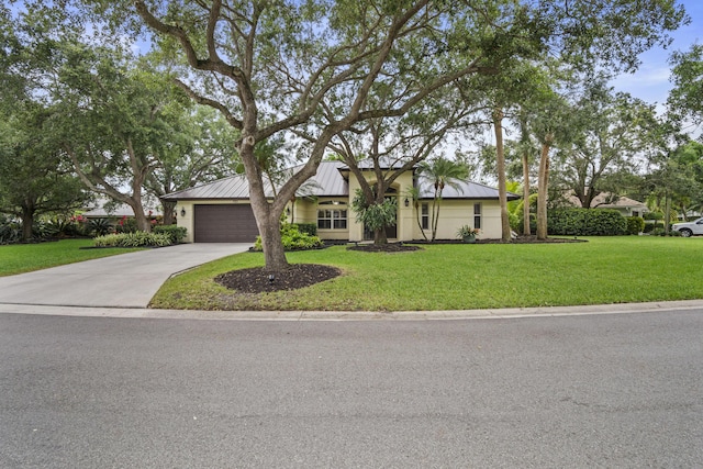721 SW Lighthouse Dr, Palm City, FL 34990 - mid-century inspired home featuring concrete driveway, a standing seam roof, a garage, and a front yard