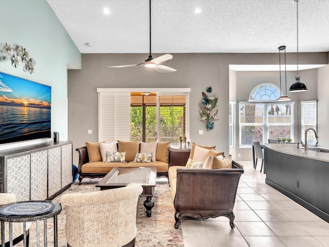 living room featuring a textured ceiling, a ceiling fan, light tile patterned floors, and recessed lighting