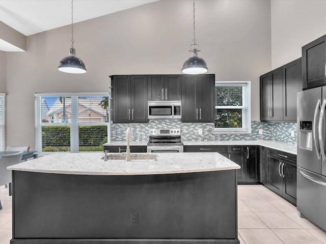 kitchen featuring stainless steel appliances, a sink, high vaulted ceiling, and dark cabinets