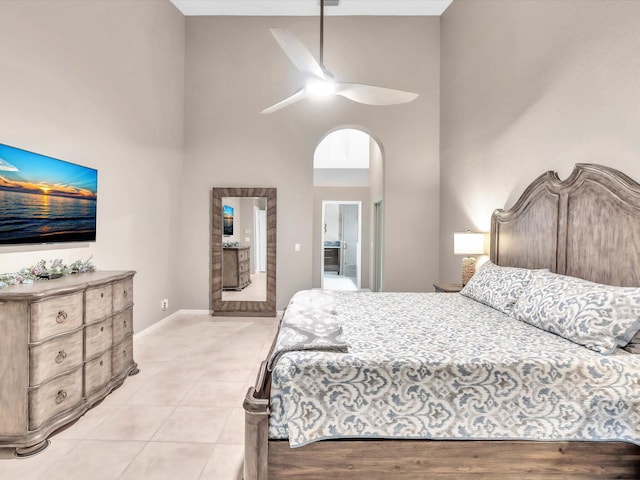 bedroom with a towering ceiling, light tile patterned floors, and baseboards