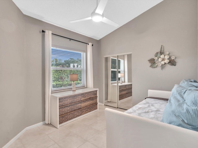 bedroom with vaulted ceiling, a ceiling fan, light tile patterned floors, and baseboards