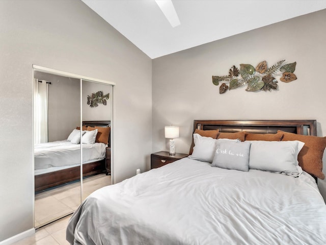 bedroom featuring a closet, light tile patterned floors, and high vaulted ceiling