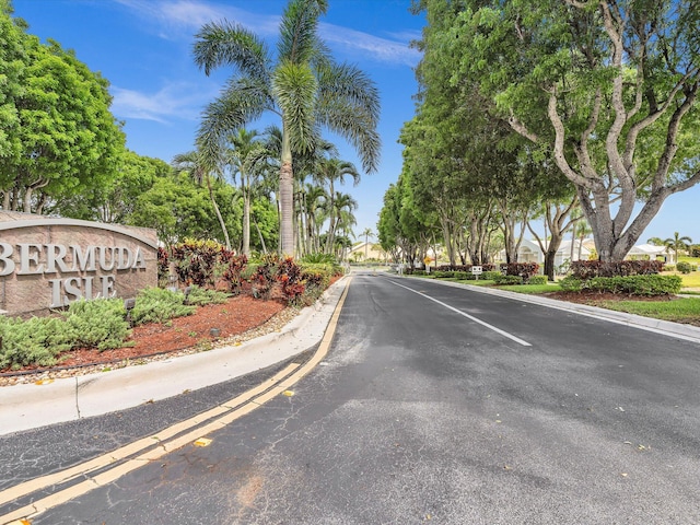 view of asphalt road with curbs